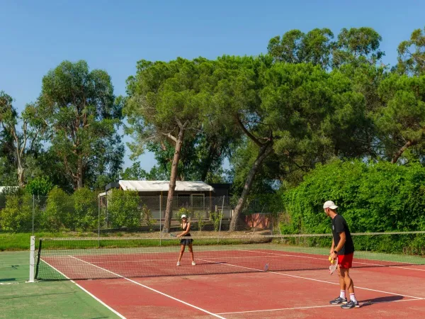 Marito e moglie giocano a tennis al campeggio Roan Arinella Bianca.