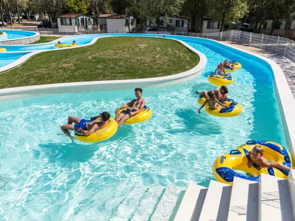 Bambini tra le ruote sul fiume pigro del campeggio Roan Marina Julia Camping Village.