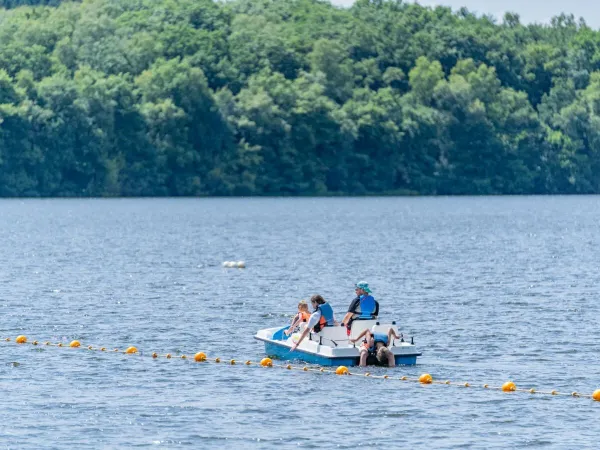 Le famiglie si divertono con i pedalò sul lago al campeggio Roan Le Lac des Vieilles Forges.