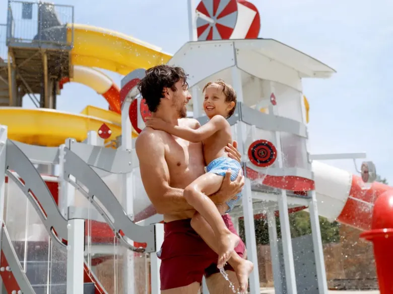 Gioco di uomo e bambino nella piscina del campeggio Roan.