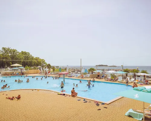 Panoramica della vivace piscina del campeggio Roan Zelena Laguna.
