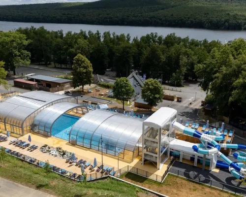Panoramica piscina con scivoli e lettini al Roan camping Le Lac des Vieilles Forges.