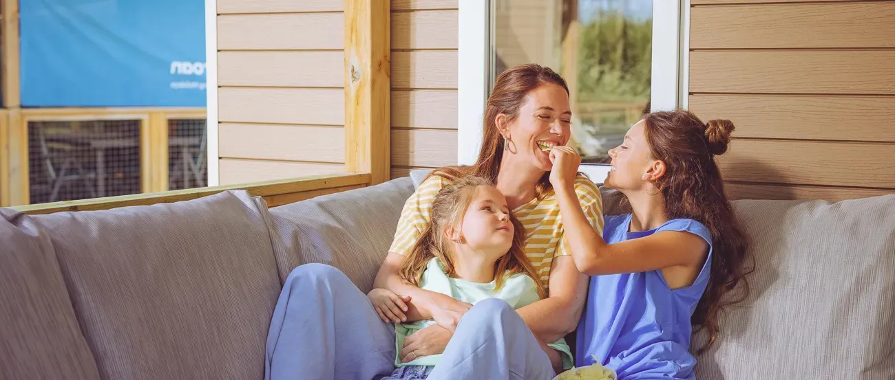 Donna sdraiata a leggere un libro al sole in una casa mobile di Roan.