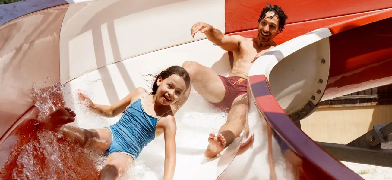 Due ragazze corrono in un parco giochi acquatico.