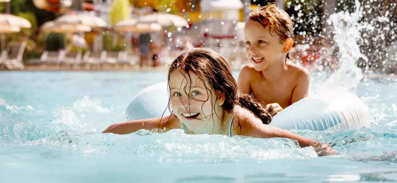 Bambini che si divertono in piscina al campeggio Roan.
